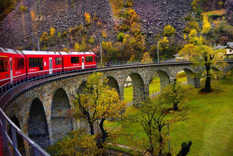 Bernina Express train crossing a viaduct in Switzerland.